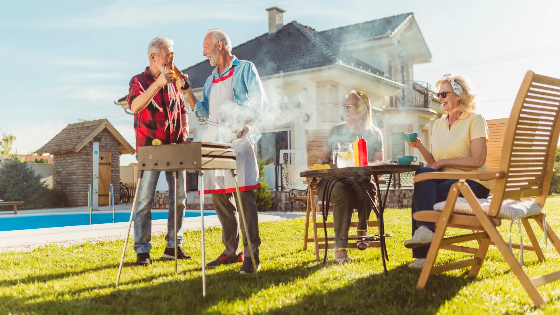 A group of retirees barbecuing in a backyard.