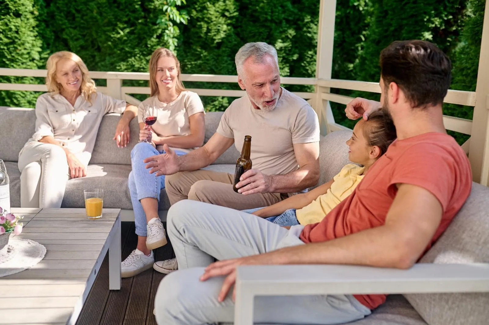 Family members lounging on a patio in their backyard.